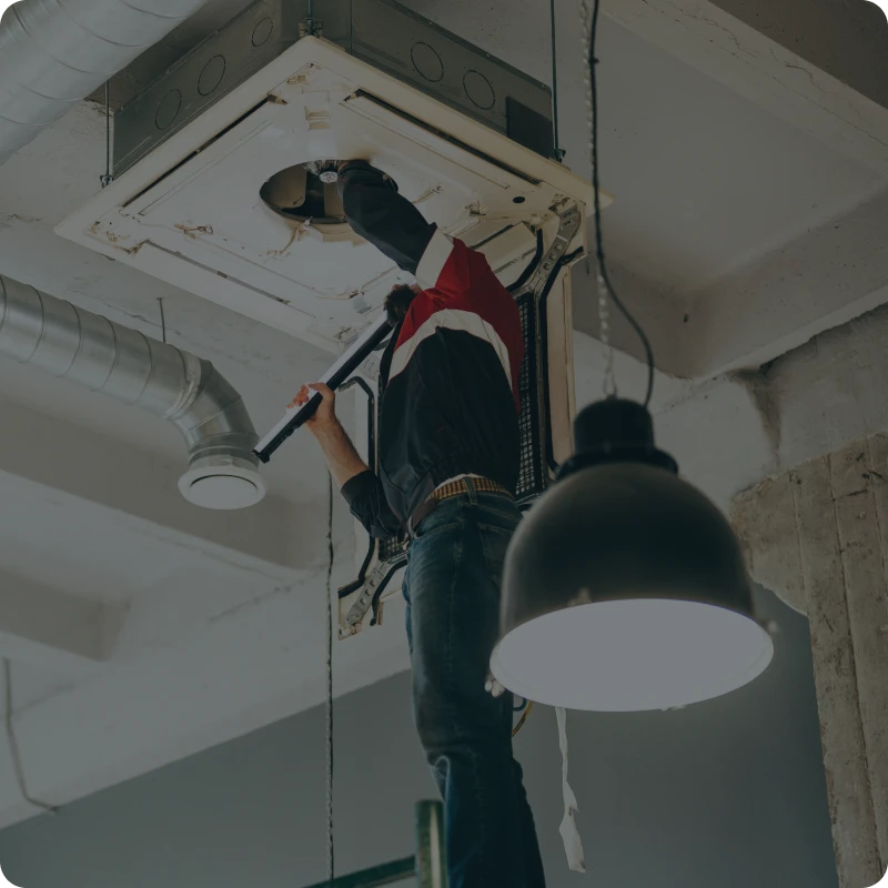 Person fixing industrial ceiling vent system